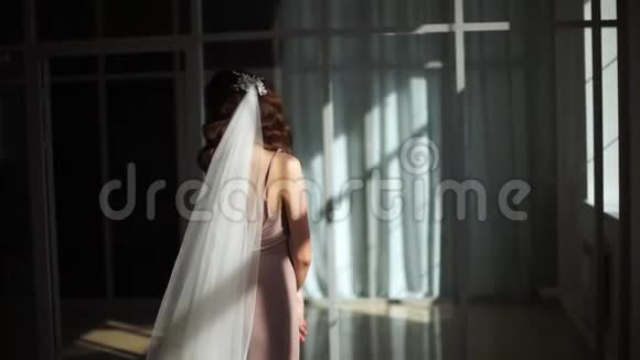 新娘的模特正沐浴在从窗户发出的阳光中视频的预览图