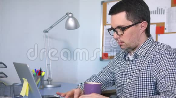 经理坐在他的工作地点在笔记本电脑上打字视频的预览图