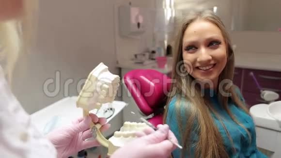 医生向她的病人解释了塑料牙齿模型的问题视频的预览图