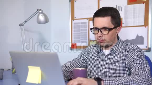 经理坐在他的工作地点在笔记本电脑上打字视频的预览图