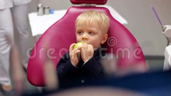 可爱的小男孩在牙科办公室吃苹果视频的预览图