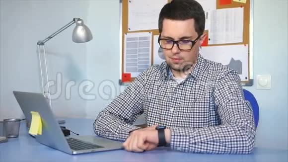 商人在他的办公室工作手上拿着智能手表的人视频的预览图