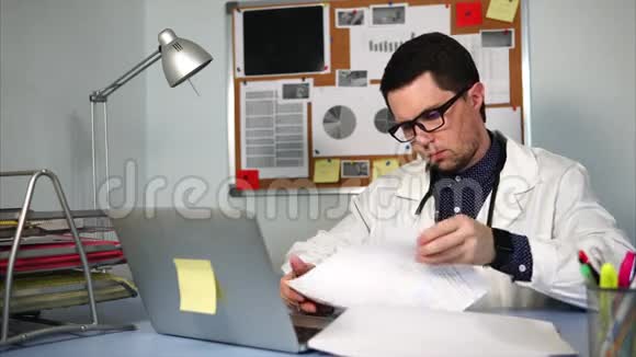 医疗助理在工作场所工作带笔记本和医疗表格视频的预览图