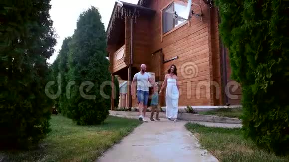 爸爸妈妈和儿子一起散步幸福的一家人在家后院散步视频的预览图