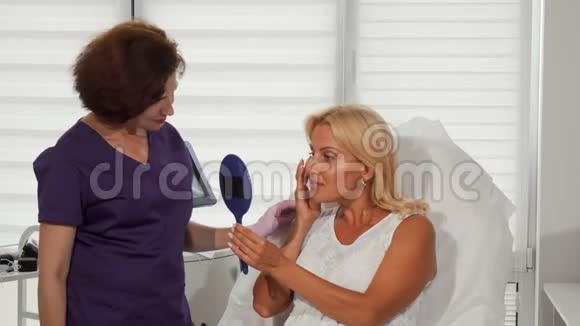 美丽的女人和她的美容师对着镜头微笑视频的预览图