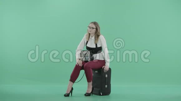 一个疲惫的女商人坐在行李上视频的预览图