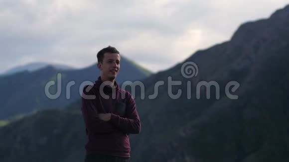 年轻英俊的男人走在山里一个男子游客走在山的背景上的景观视频的预览图