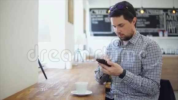 一个成年人坐在咖啡屋里用电话交流视频的预览图