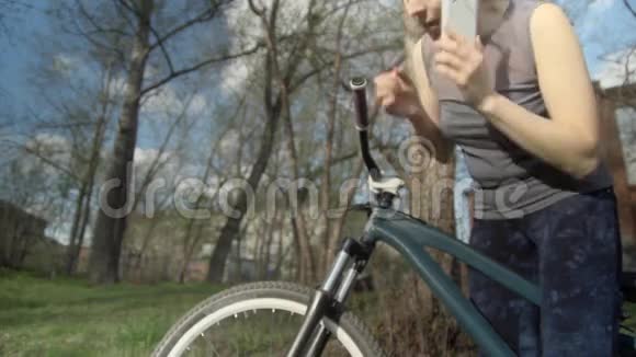 年轻的骑自行车的人在电话里讲话试图让轮胎充满空气视频的预览图