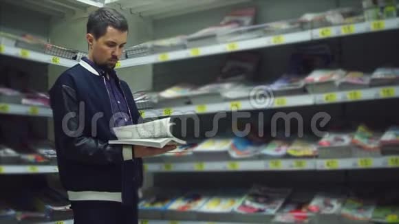 超市里的男顾客他手里拿着一本大杂志视频的预览图
