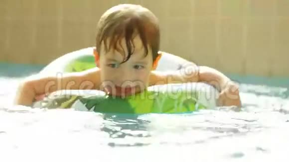 快乐的小男孩带着橡皮圈游泳视频的预览图