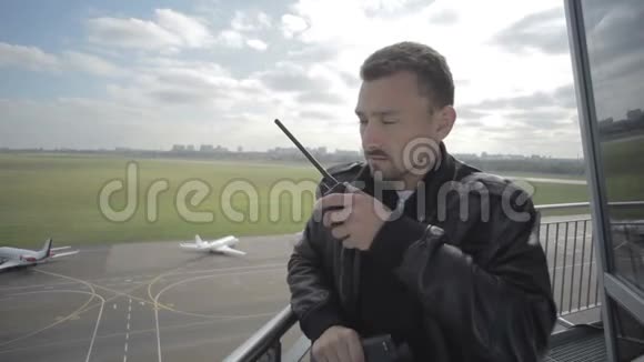 调度员使用便携式无线电和望远镜来控制机场的空中交通视频的预览图