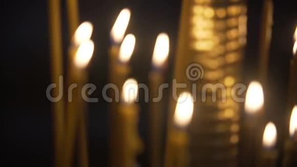 在教堂的黑色背景下点燃蜡烛点燃蜡烛特写镜头视频的预览图