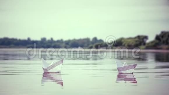 两只小纸船漂浮在水面上视频的预览图