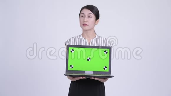快乐美丽的亚洲女商人一边思考一边展示笔记本电脑视频的预览图