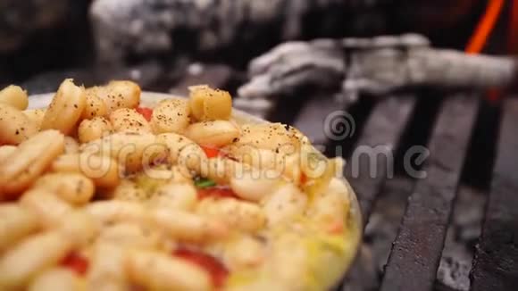 在森林营火橙火烧烤盘上准备的美味的哈立可豆罐头沙拉近距离观看视频的预览图