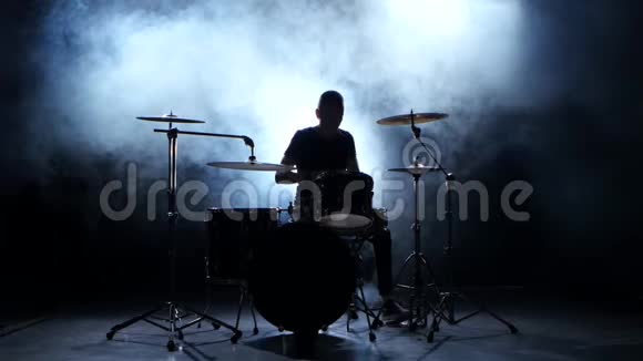 精力充沛的音乐家在鼓上演奏好音乐黑色烟熏背景剪影视频的预览图