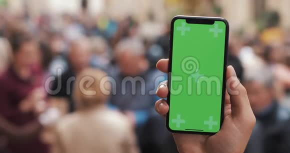 近距离拍摄男子手拿智能手机与绿色屏幕上的城市街道背景铬键视频的预览图