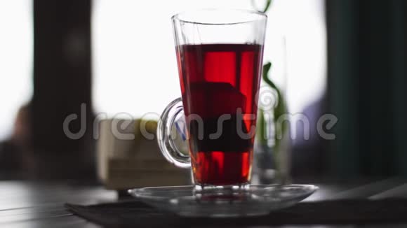 玻璃杯茶里面放着茶袋放在黑暗的餐厅大厅的桌子上视频的预览图