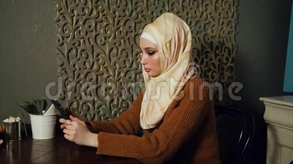 一位现代阿拉伯妇女在咖啡馆用手机与朋友交流视频的预览图