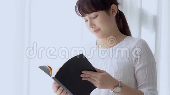美丽的肖像年轻的亚洲妇女放松站立学习与阅读书考试在卧室在家里视频的预览图