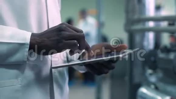 科学家在实验室里用手点击平板电脑视频的预览图
