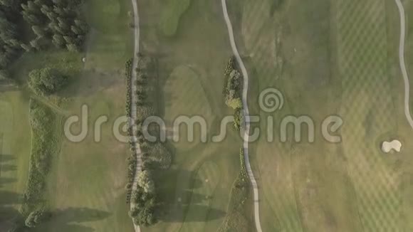 从大型豪华高尔夫球场上方射击绿色草坪和树木的景色从上面拍摄俯视无人机视频的预览图