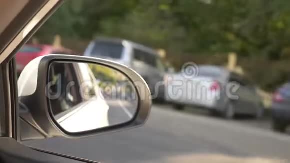 查看后视镜当汽车在夏天沿着道路行驶时4k慢镜头拍摄视频的预览图