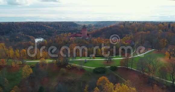Turaides城堡秋季森林Sigulda城市自然高亚河无人机飞行桥车从上面行驶视频的预览图