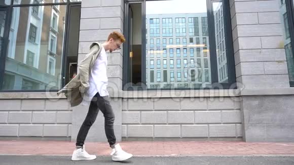 一位穿着时髦衣服的年轻时尚男子在现代城市漫步视频的预览图