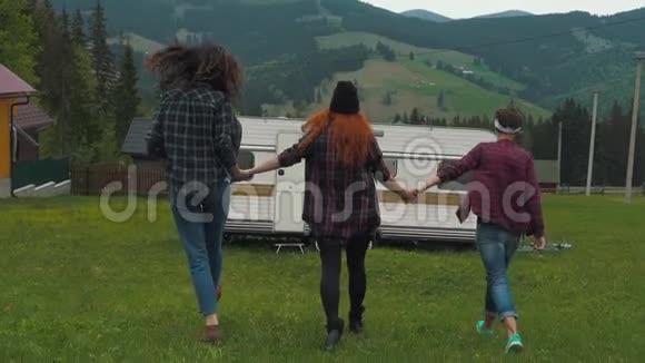 女孩们牵着手跑在山里的拖车附近视频的预览图
