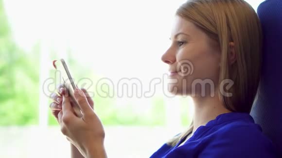 女游客乘火车旅行使用她的智能手机浏览阅读新闻和朋友聊天视频的预览图