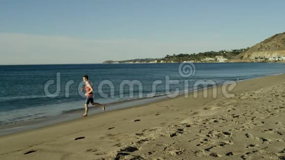 年轻运动员在阳光明媚的海岸上快乐地奔跑视频的预览图