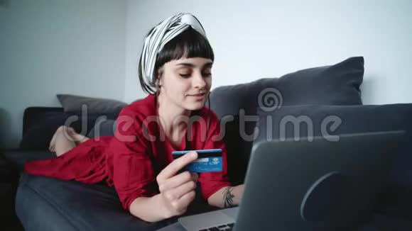 年轻的黑发女人用信用卡支付网上的费用视频的预览图