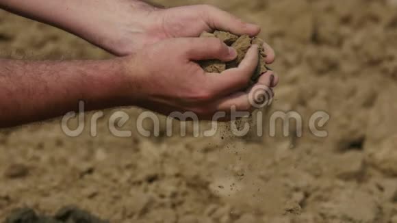 农民双手紧握干燥的土壤视频的预览图