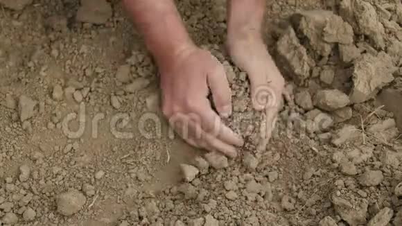 农民双手紧握干燥的土壤视频的预览图