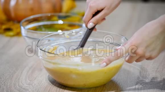不可辨认的女性糖果手用铲子将面包屑和鲜奶油混合在碗碗中合上视频的预览图