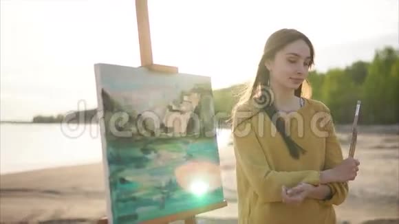 在阳光明媚的户外女艺术家和她的风景画视频的预览图