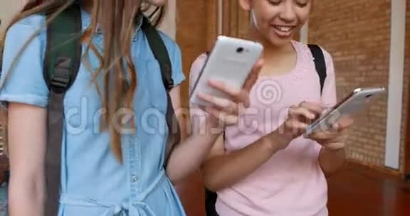 在篮球场上使用手机的快乐女学生视频的预览图