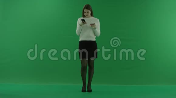 女孩在绿色屏幕上从手机里的信用卡输入数据视频的预览图