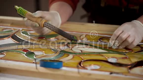 熟练的工人正在用锡焊锡在染色玻璃上覆盖铜视频的预览图
