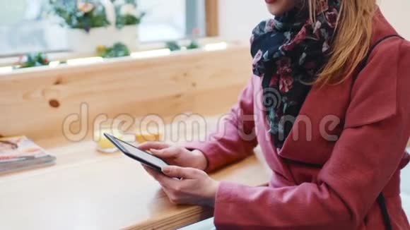 舒适的咖啡馆一个的内部漂亮的欧洲女孩穿着时尚的休闲服坐在窗边用她的袖珍书视频的预览图