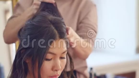 专业的发型师发型师梳着一个美丽模特的头发有着亚洲的外表美容美发护理视频的预览图