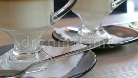 在咖啡馆的一张桌子上的茶托上放着咖啡拿铁支架的一些玻璃杯视频的预览图