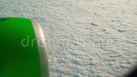一架绿色飞机引擎飞过云层时倾斜的镜头视频的预览图