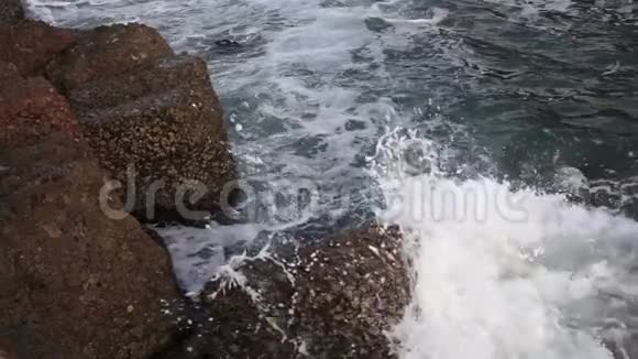海浪拍打着海滩上的岩石慢动作视频的预览图