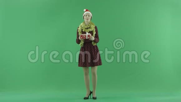 一位年轻女子正在绿色屏幕上为观众赠送圣诞礼物视频的预览图