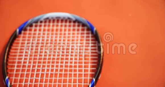 红色地板4k上网球腕带和球拍的特写视频的预览图