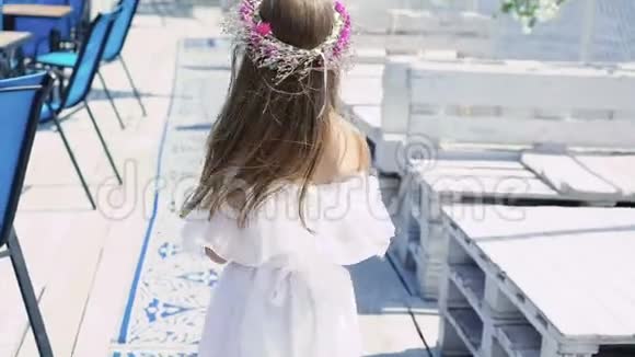 小女孩走在酒吧湾上带着花旋转慢慢地视频的预览图
