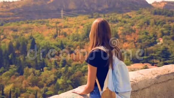 女人站着看望远镜山神奇的风景阳光多风自由飞翔长发享受旅行视频的预览图